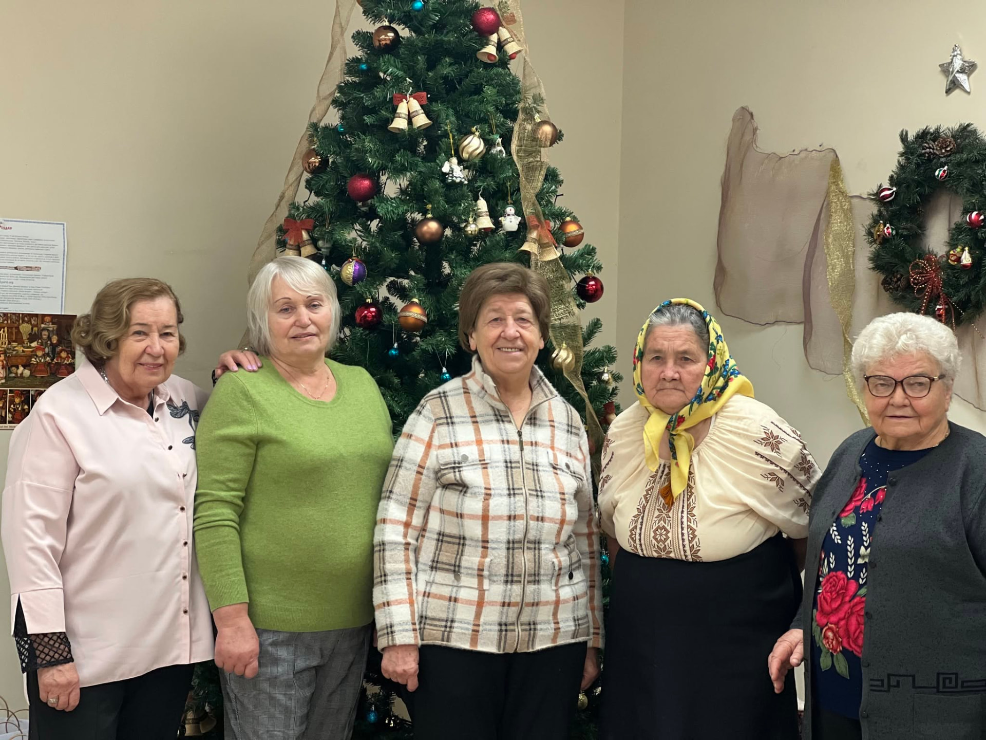Participants gathered beside a decorated holiday tree